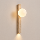 Wall-mounted light fixture with a cylindrical wooden casing and round glass shade on a neutral wall.