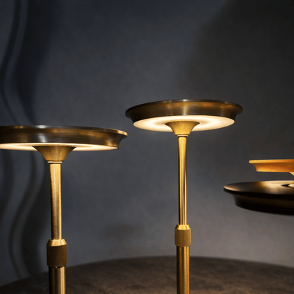 Three gold candle holders against a dark background