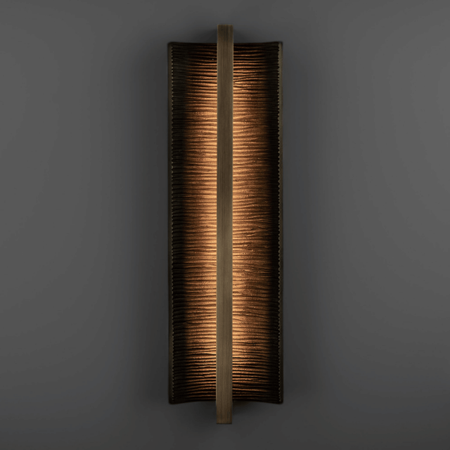 Rectangular wall sconce with a textured finish on a dark background