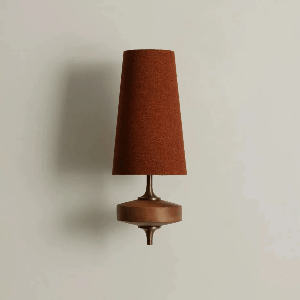 Wall-mounted lamp with a brown cone-shaped shade on a beige background