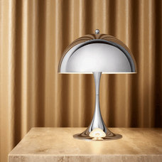 Modern table lamp on a wooden surface with a brown curtain background