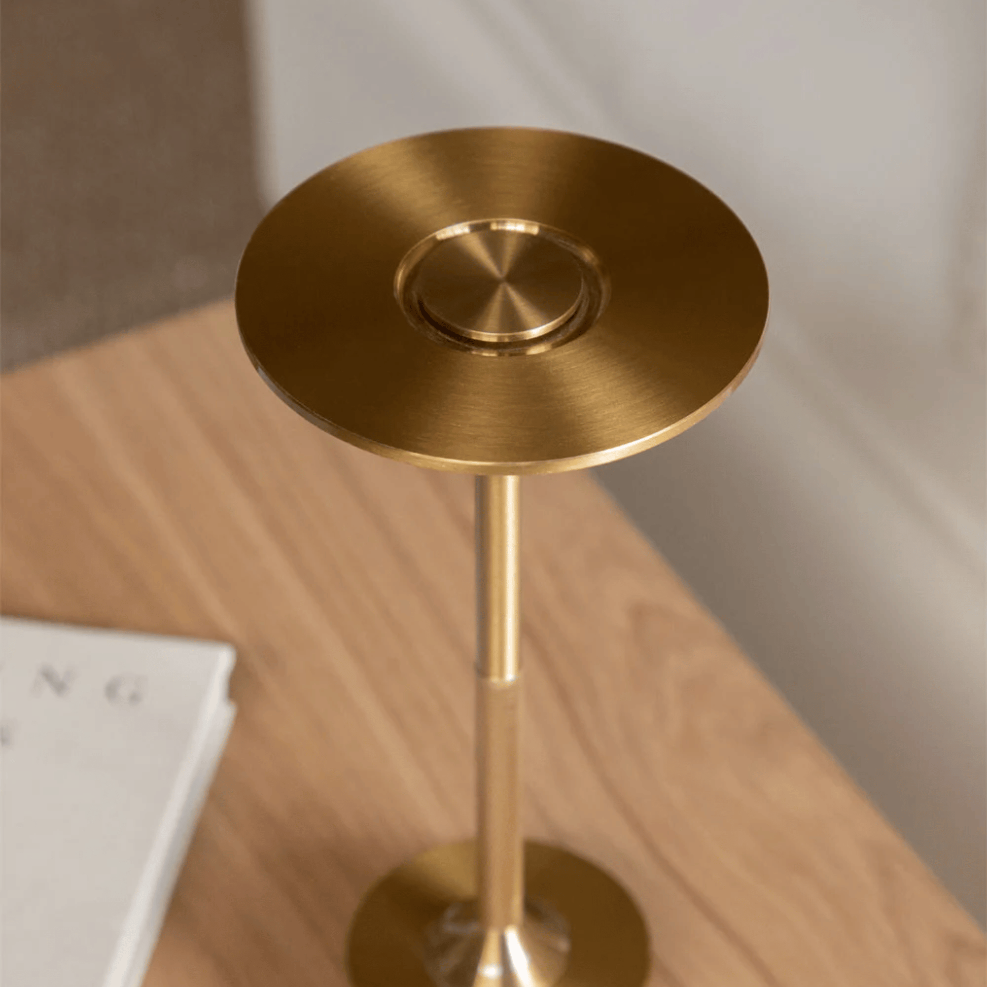Gold metal stool on a wooden surface with a neutral background
