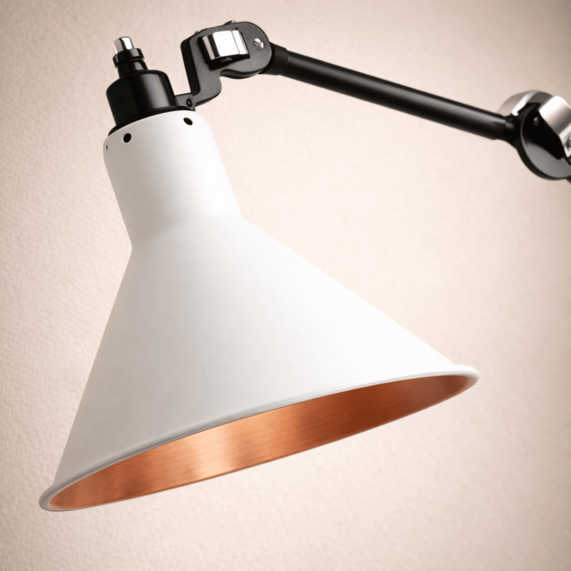 Modern wall-mounted lamp with white shade and copper interior on a beige background