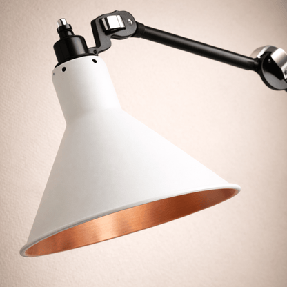 Modern wall-mounted lamp with white shade and copper interior on a beige background
