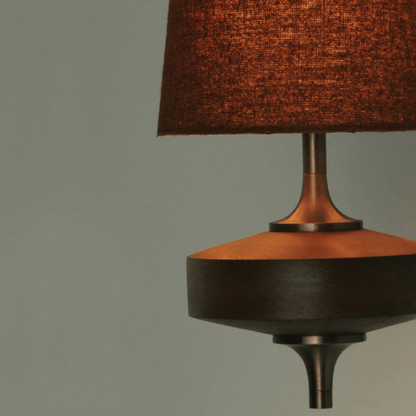 Close-up of a brown textured lampshade on a dark base against a gray background