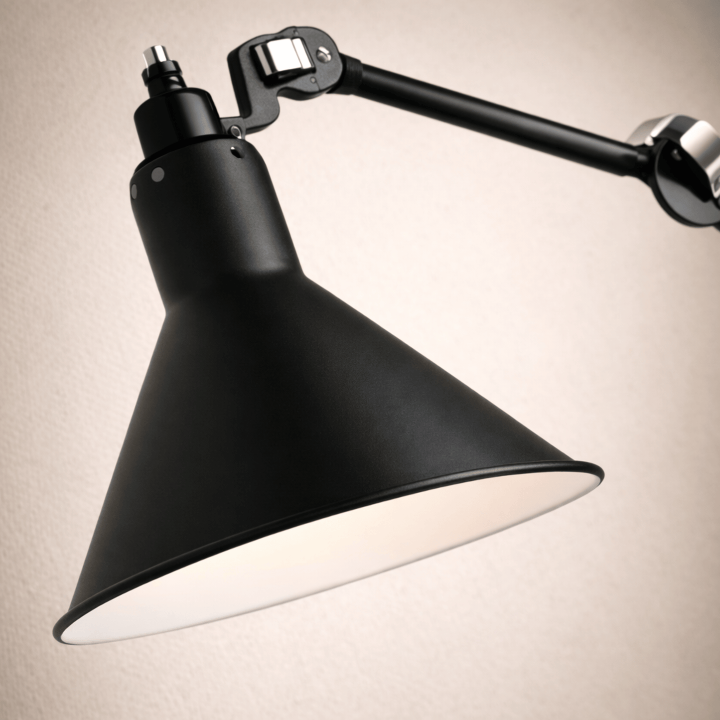 Black industrial-style wall lamp on a beige background