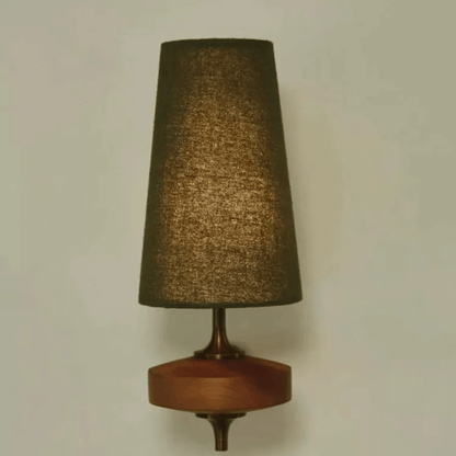 Wall-mounted lamp with a textured brown shade and wooden base on a plain wall.