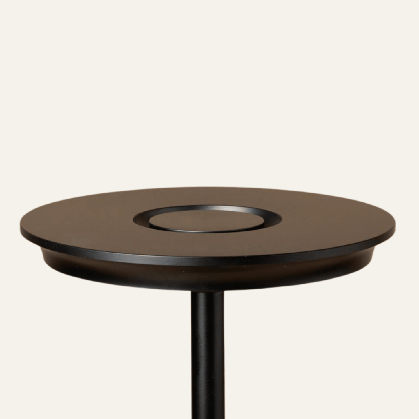 Round wooden table with a black base on a white background