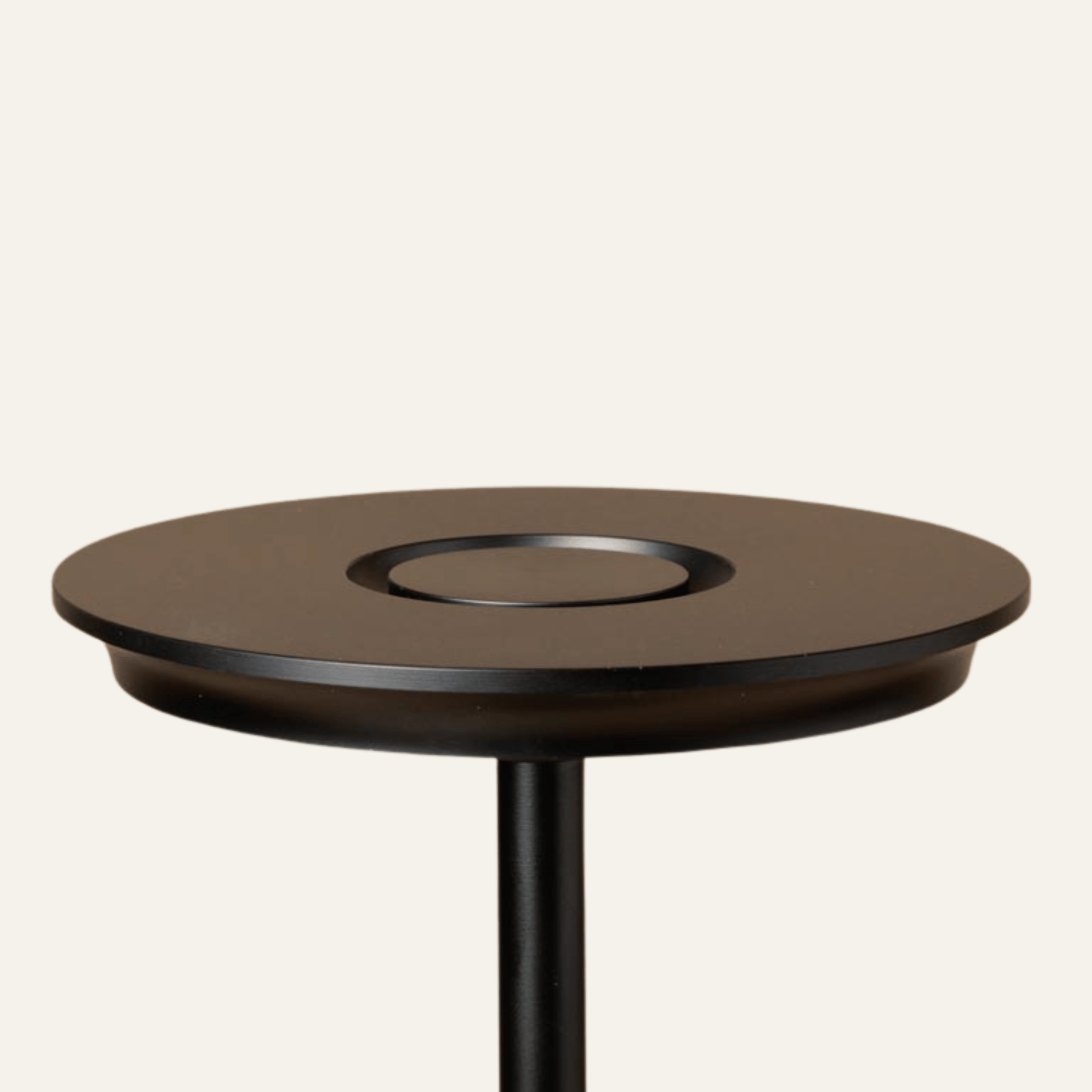 Round wooden table with a black base on a white background