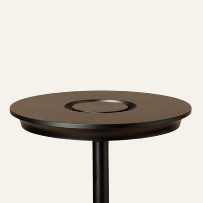 Round wooden table with a black base on a white background
