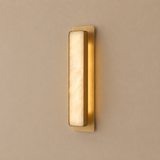 Gold wall sconce on a beige wall