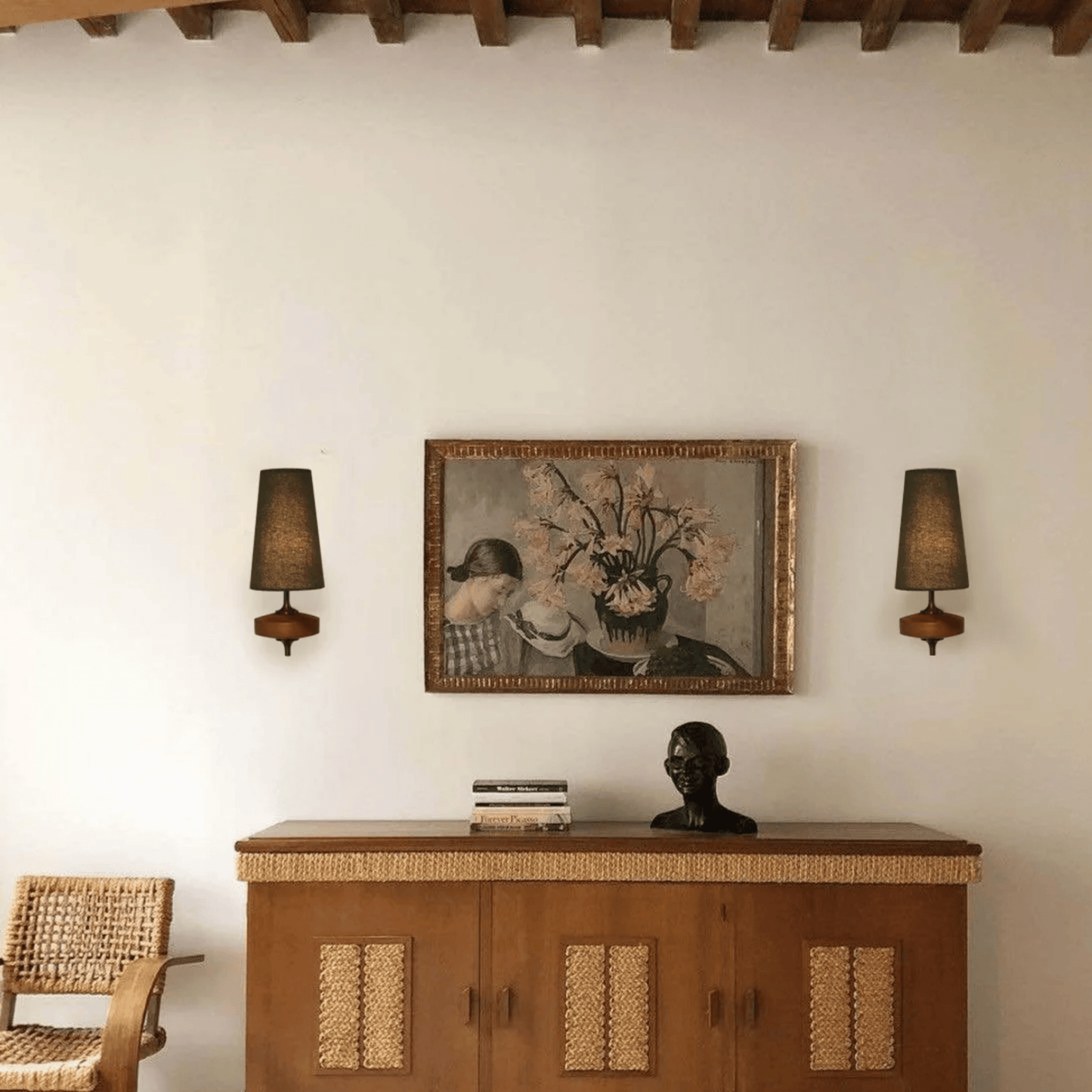 Room interior with wooden cabinet, wall art, and lamps.
