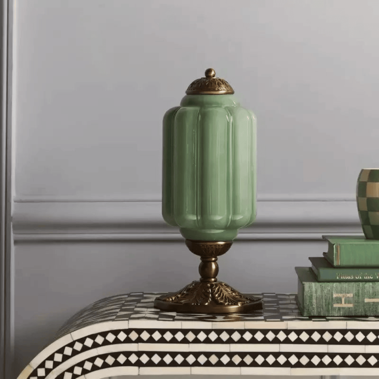 Green ceramic lamp with gold accents on a decorative table
