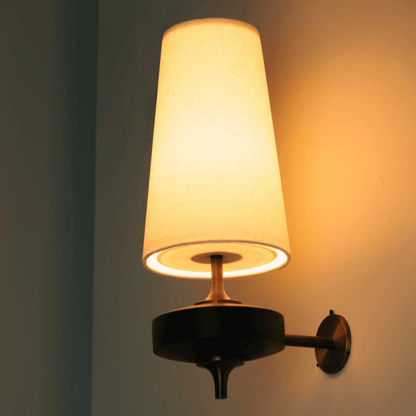 Wall-mounted lamp with a warm glow on a plain wall