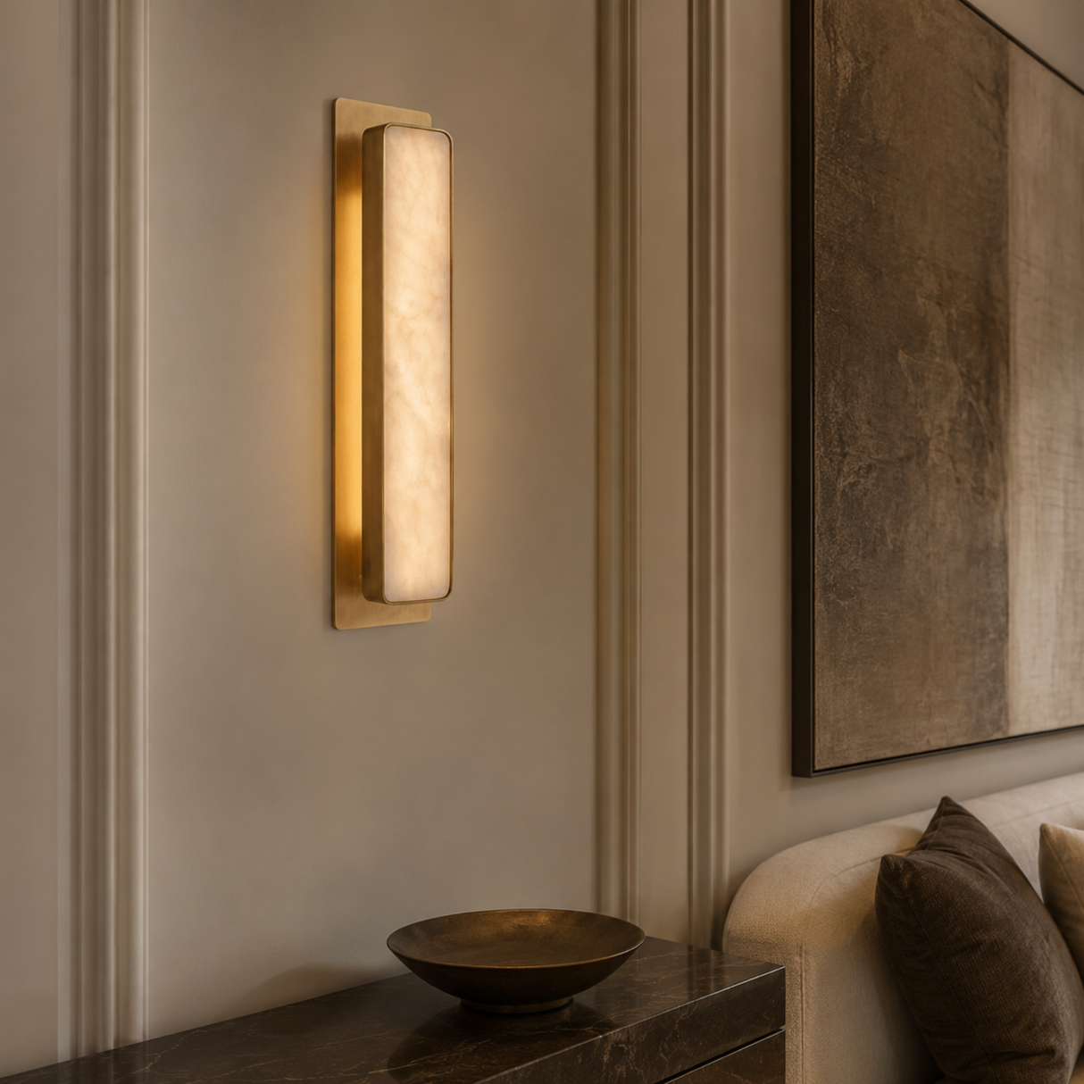 Wall-mounted light fixture in a room with a painting and decorative bowl.