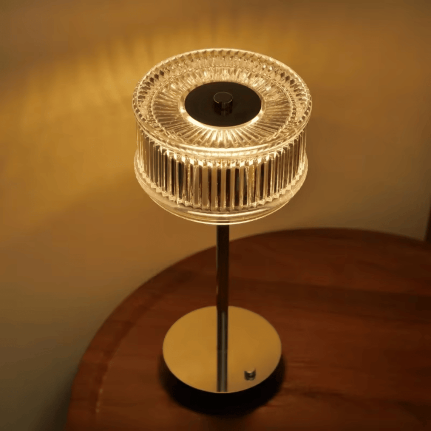 Decorative table lamp with a crystal-like shade on a wooden surface.