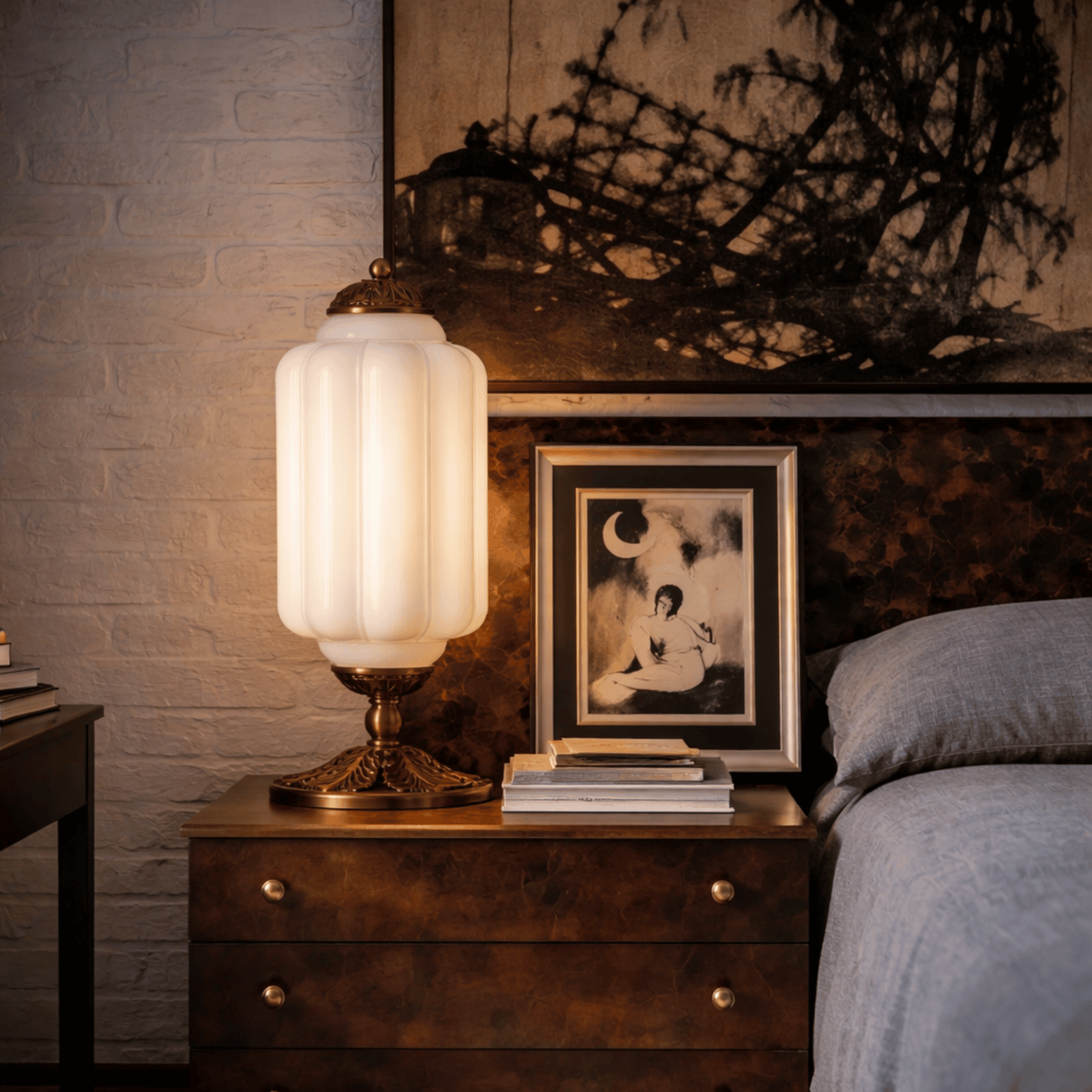Decorative table lamp on a wooden nightstand next to a bed with a framed photo.