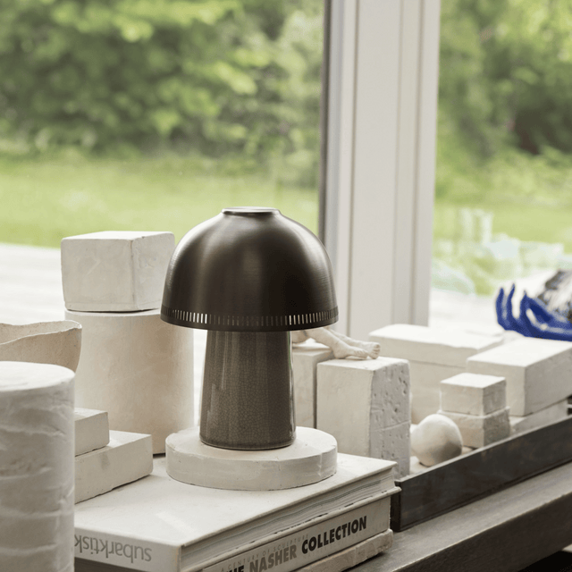 Decorative lamp on a surface with books and architectural models in the background