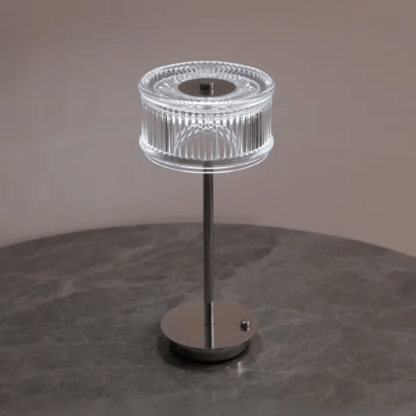 Modern table lamp with clear glass shade on a dark surface