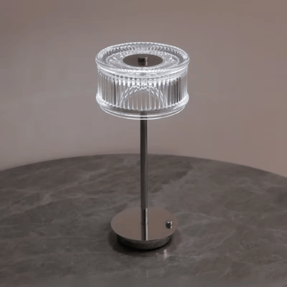 Modern table lamp with clear glass shade on a dark surface