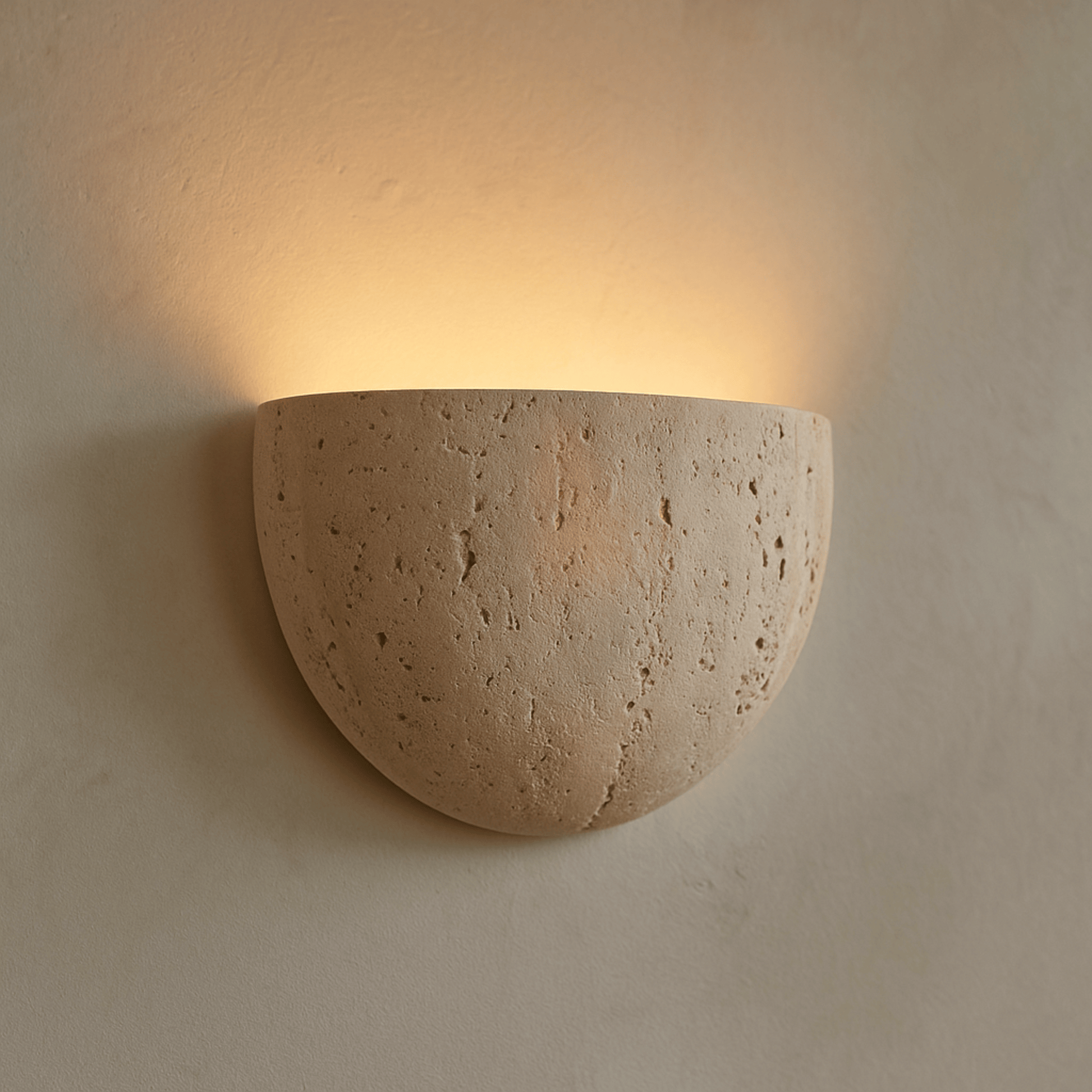 Ceramic wall sconce emitting warm light on a beige wall