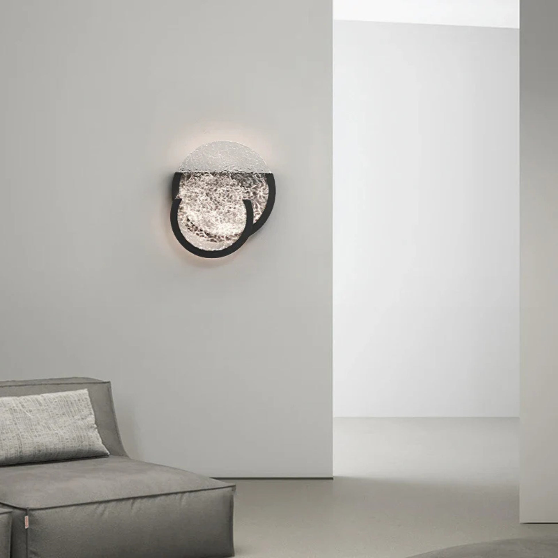 Wall-mounted light featuring two overlapping textured glass circles with a warm glow.