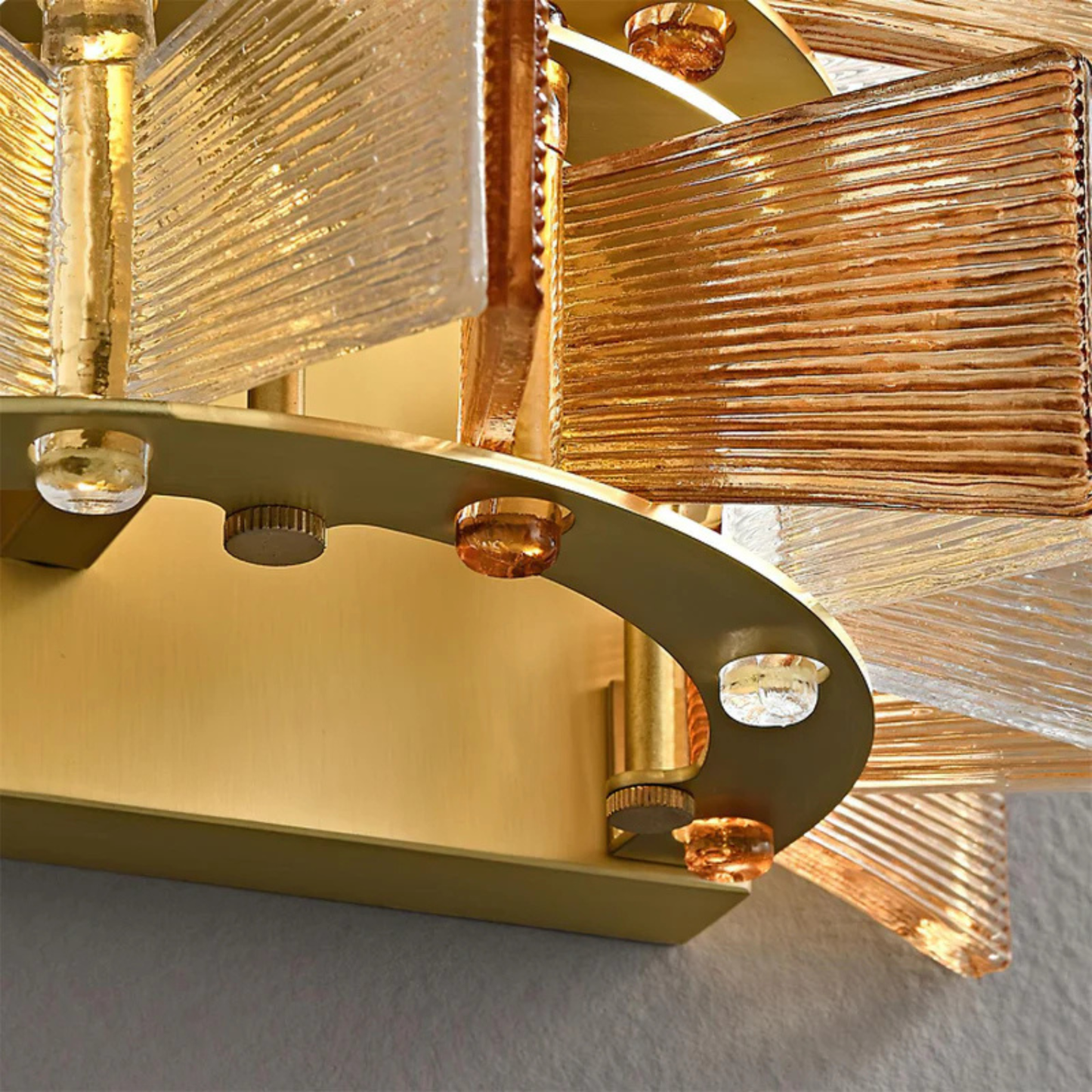 Detailed shot showing the golden metal frame and textured glass panels of the wall lamp.