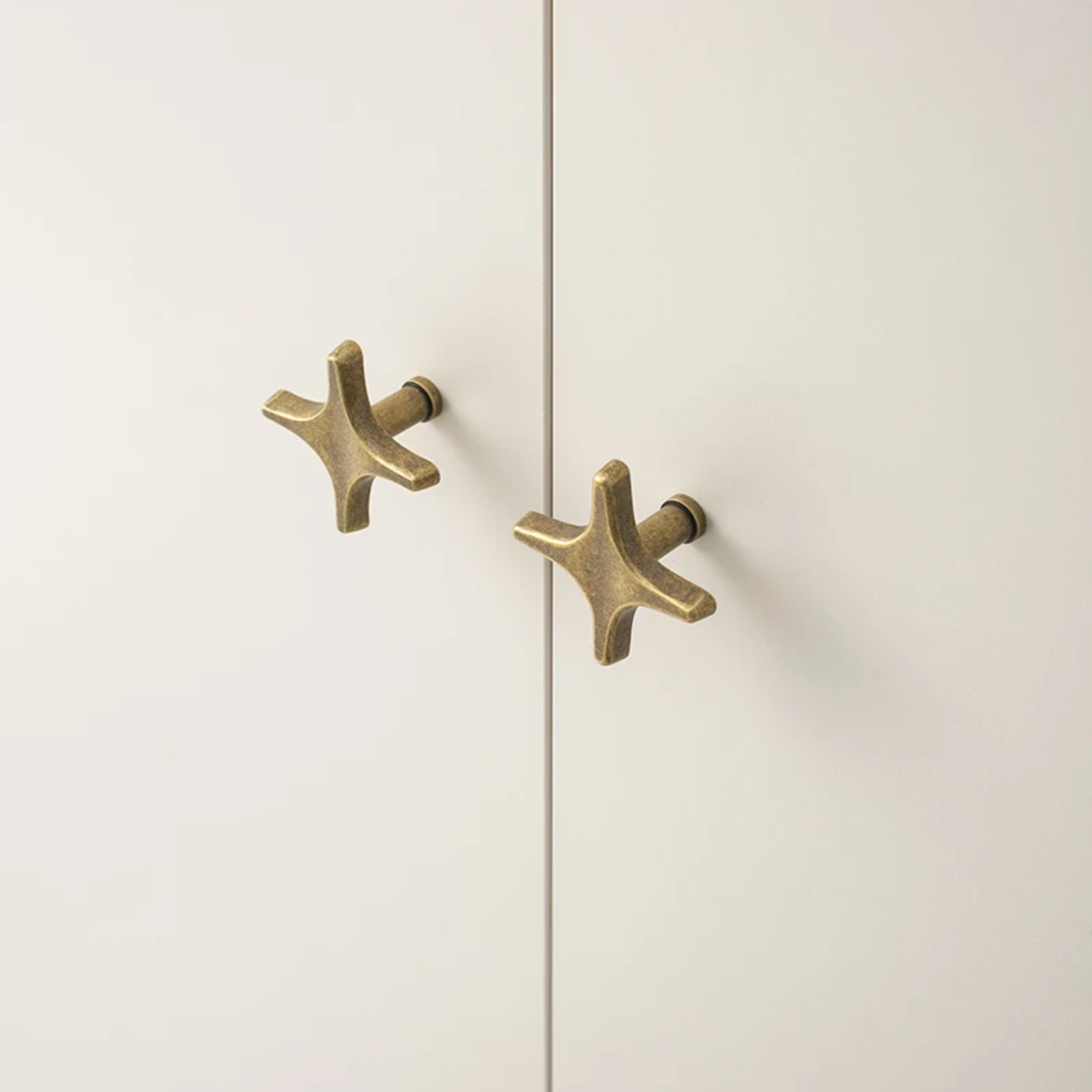 Pair of gold cabinet handles on a white door