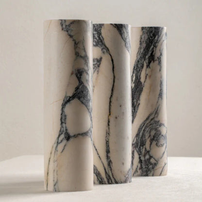 Pair of tall marble wall sconces mounted side by side on a beige wall.
