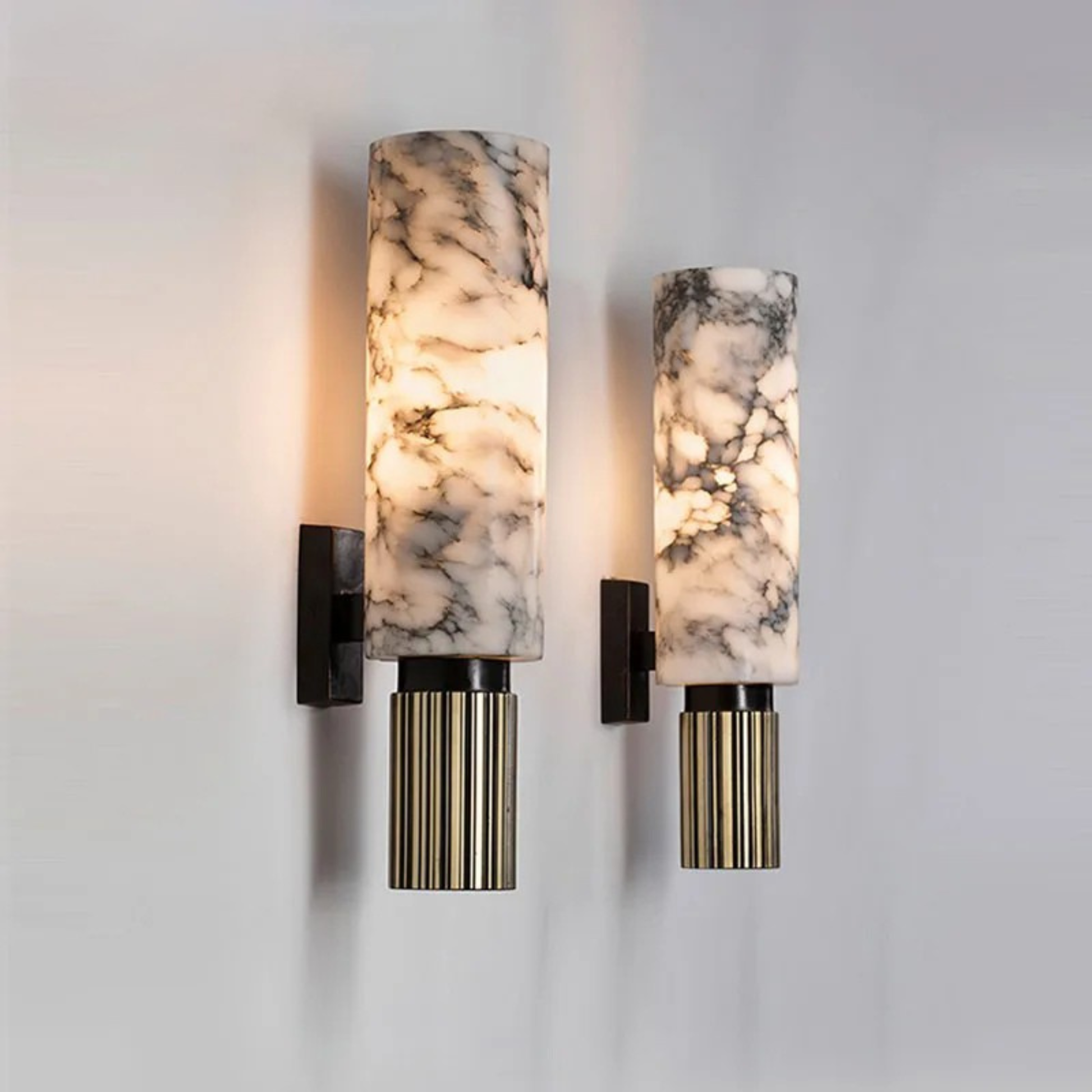 Contemporary marble and metal wall lamp illuminating a mirror wall in stylish home décor.