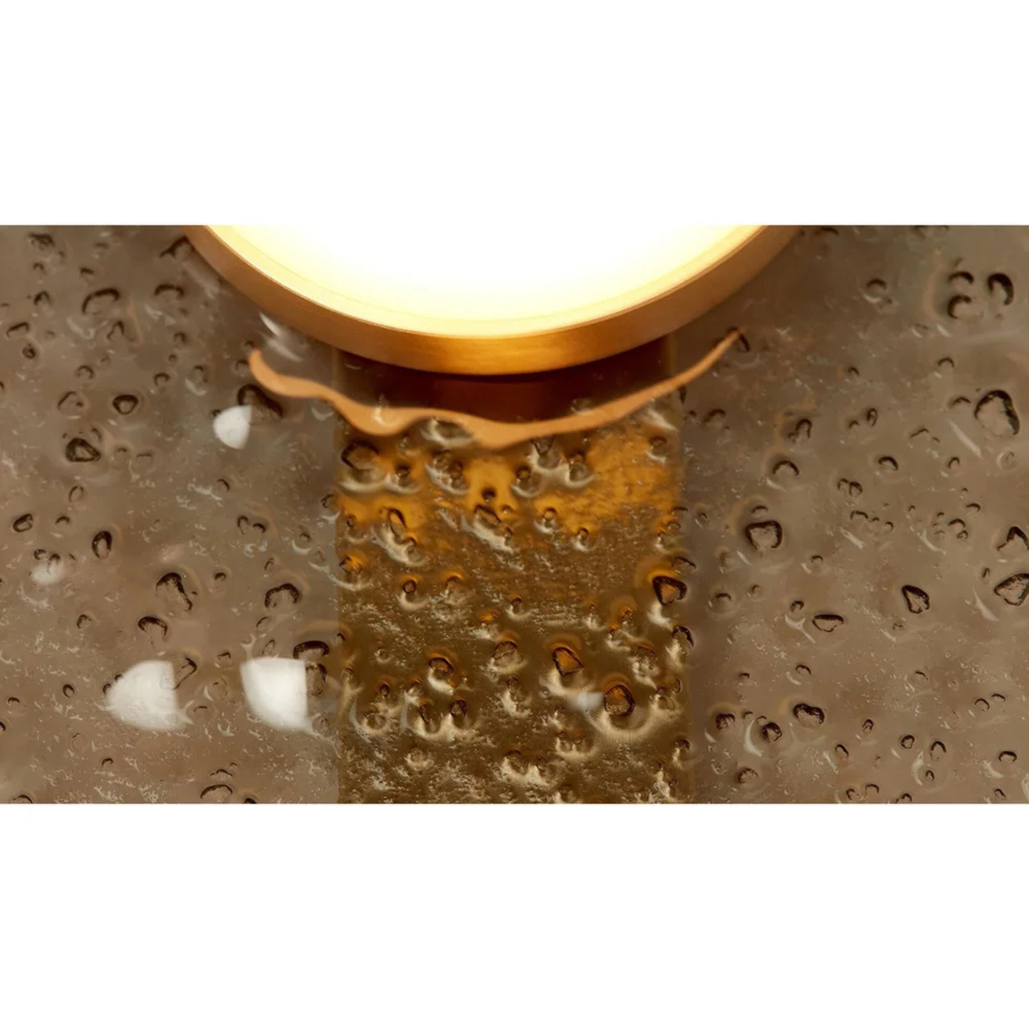 close up of hammered textured metal backplate with warm brass bulb base