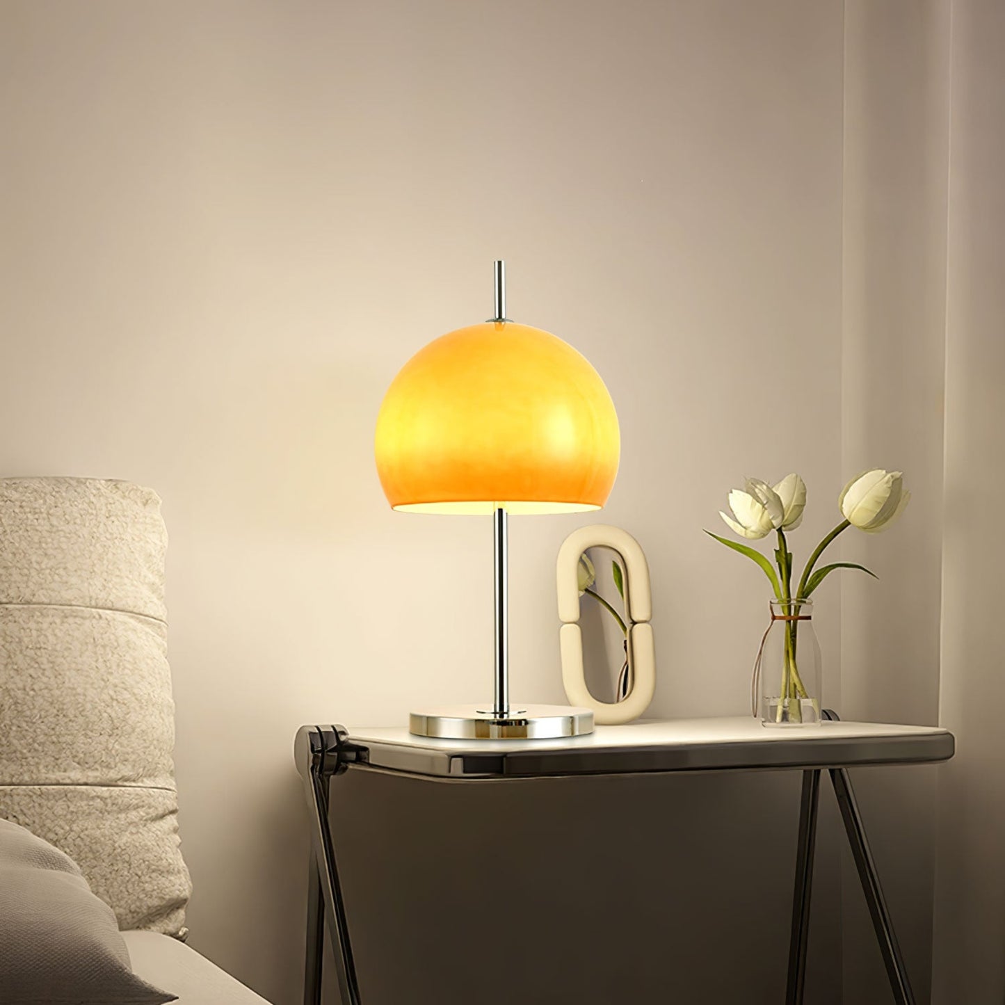 Another view of the Orange  globe lamp on a table, highlighting its clean, modern design with a polished metal base.
