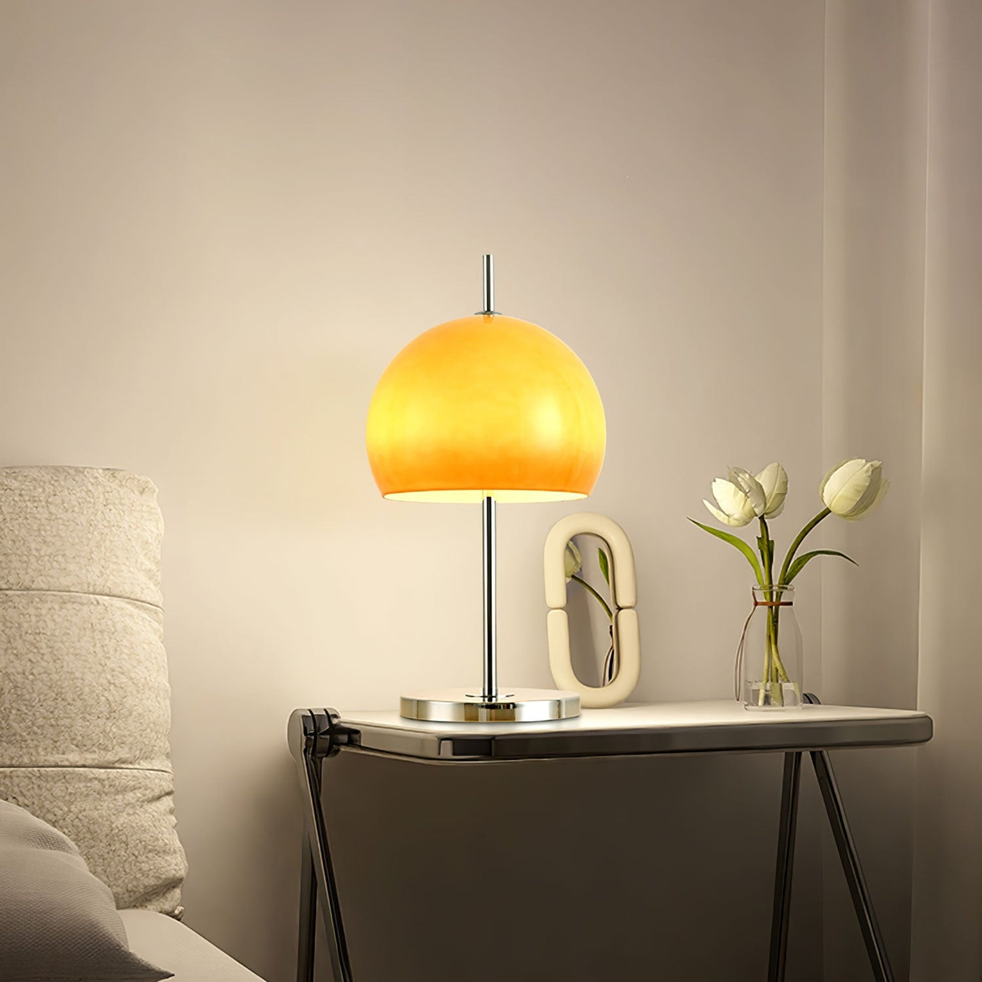 Another view of the Orange  globe lamp on a table, highlighting its clean, modern design with a polished metal base.