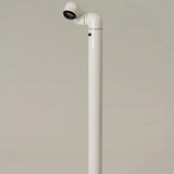 A close-up of a white floor lamp, with its light fixture pointing to a section of the floor.