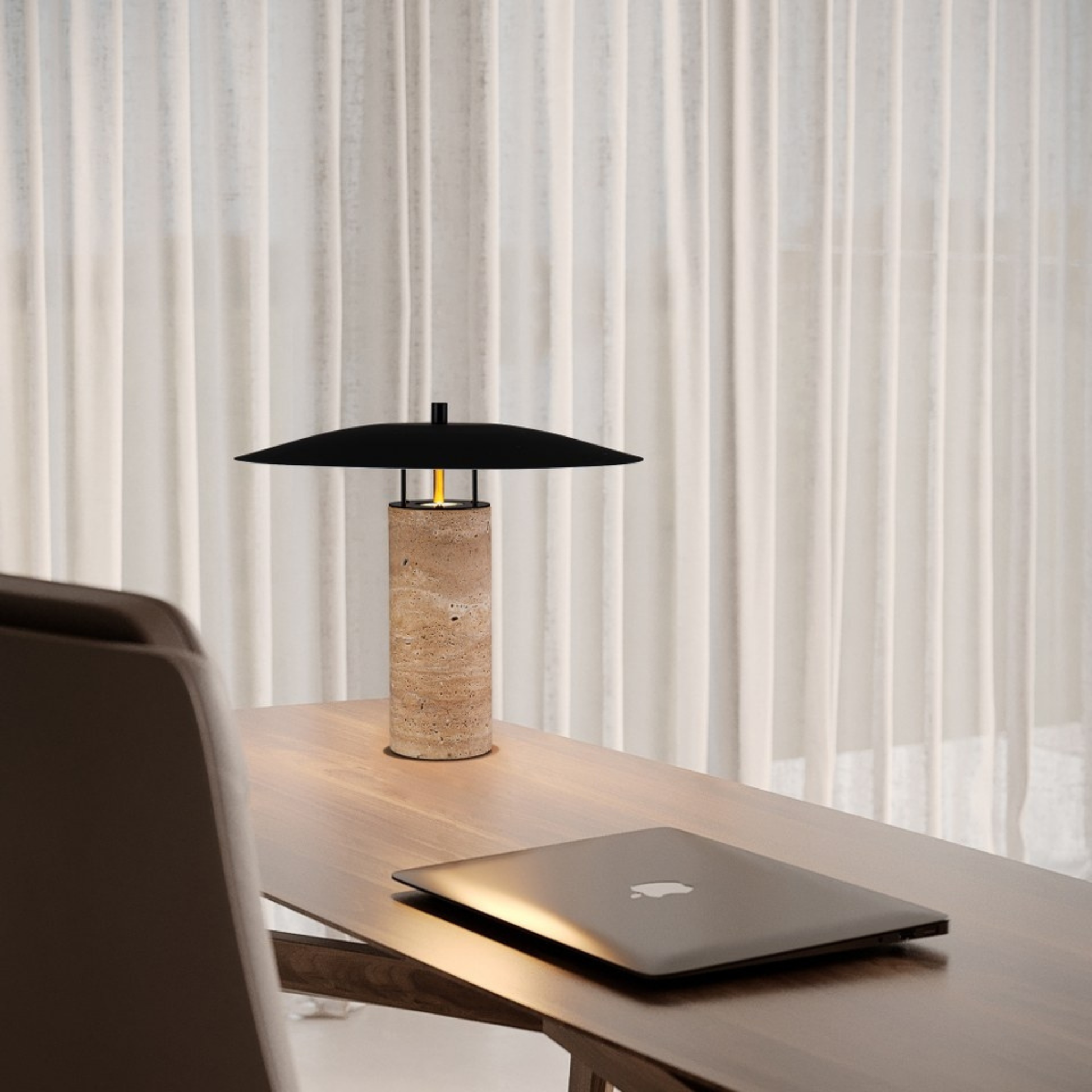 Minimal workspace with a bamboo and black metal lamp beside a closed laptop near sheer curtains