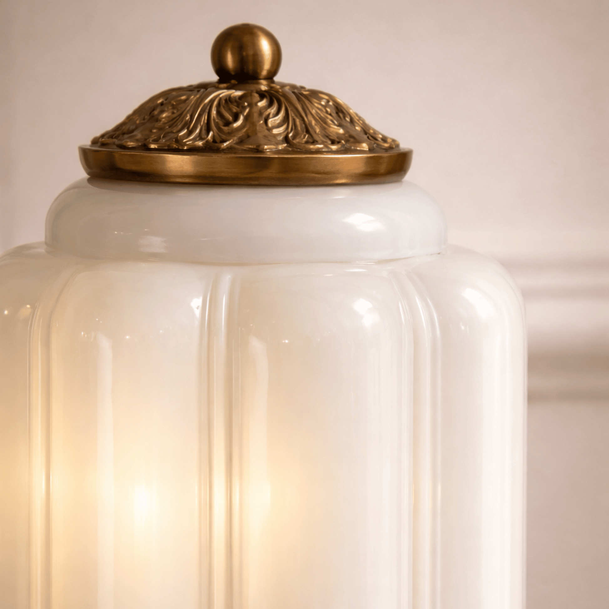 Decorative white vase with a gold lid on a beige background