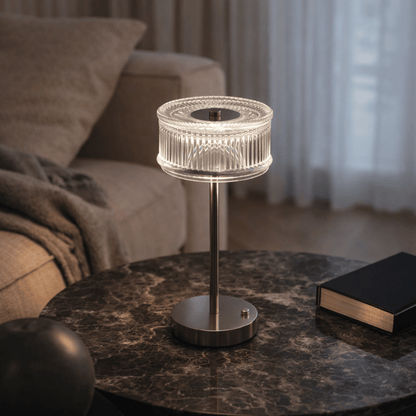 Modern table lamp on a marble surface with a blurred living room background