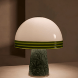 Mushroom-shaped lamp with white top and green base on a neutral background