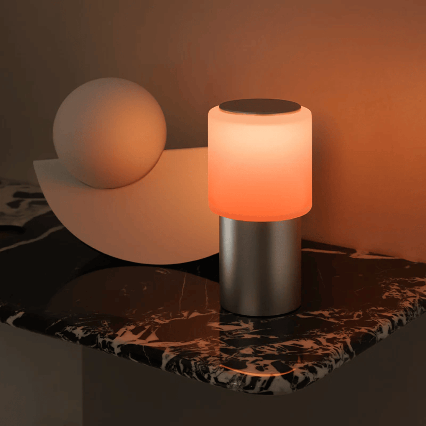 Table lamp with orange light on a marble surface
