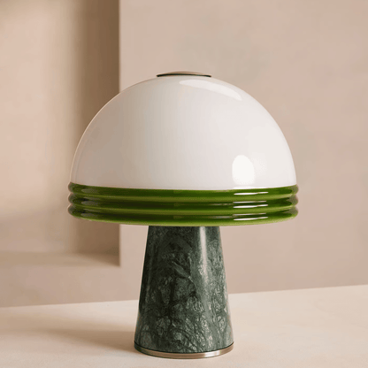 Mushroom-shaped lamp with white top and green base on a beige background