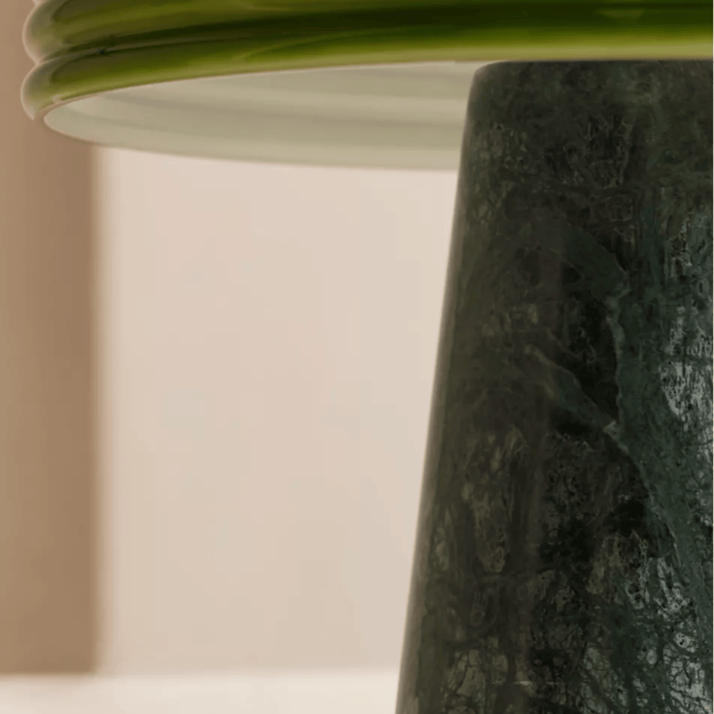 Close-up of a textured green vase against a neutral background