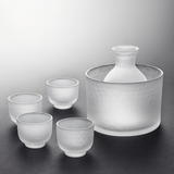 Set of frosted glass sake cups and a large container on a gray background