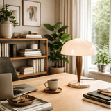 Home office with a desk, laptop, mug, books, and a lamp.