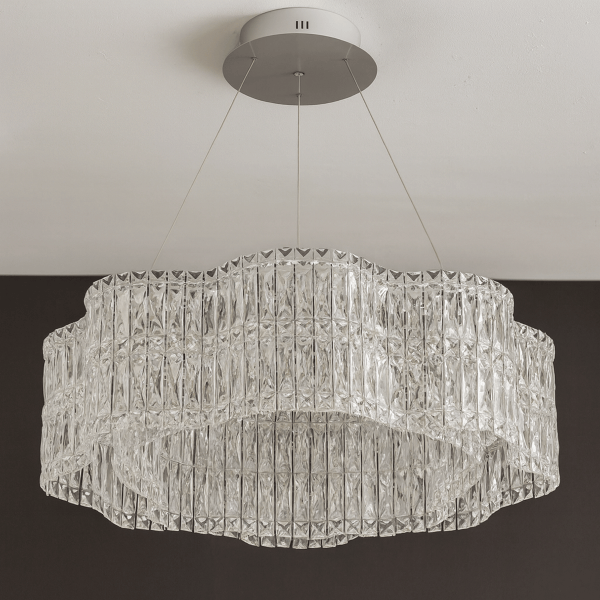 Crystal chandelier hanging from the ceiling against a neutral background