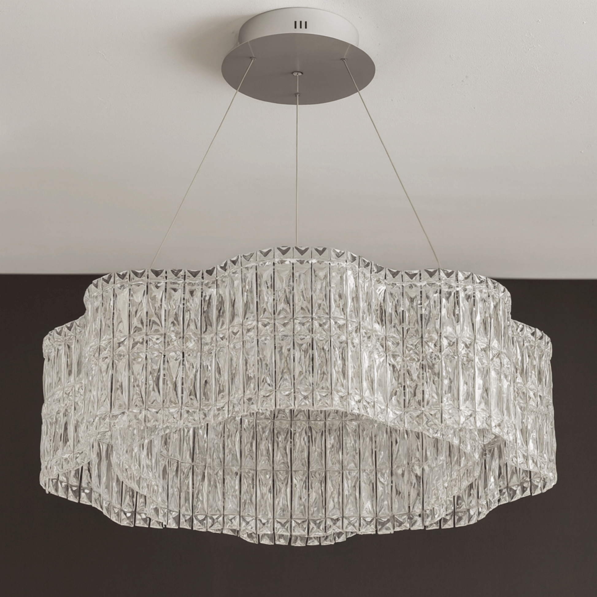 Crystal chandelier hanging from the ceiling against a neutral background