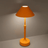 Orange table lamp on a gray surface with a dark background