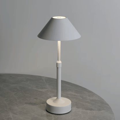 Modern table lamp with gray shade and white base on a gray surface.