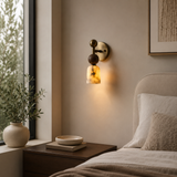 Modern bedroom with wall sconce, plant, and bed.