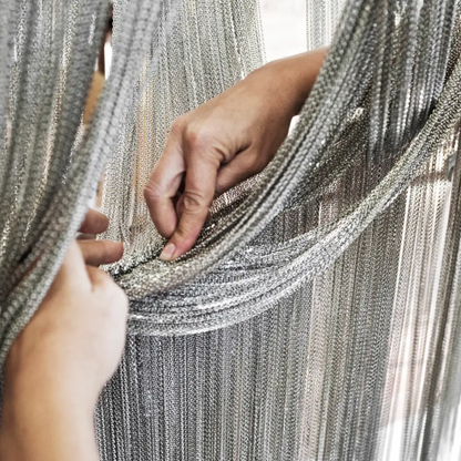 Close-up of hands holding a silver chainmail garment