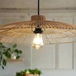 Woven pendant light with a visible bulb hanging against a neutral wall.